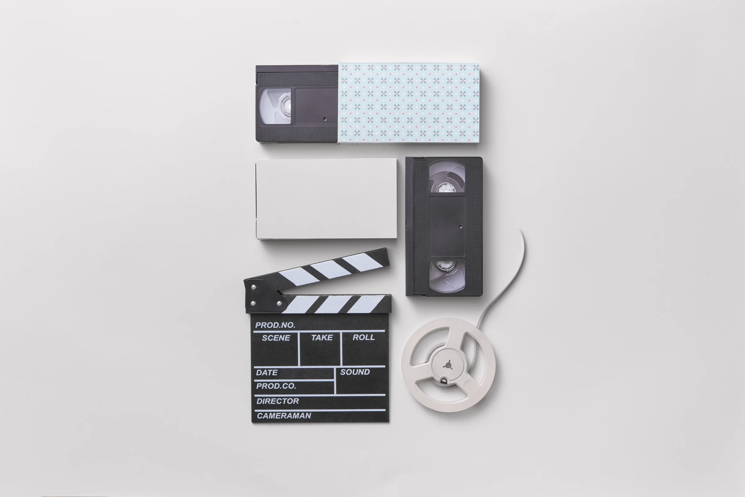 VHS tapes, clapperboard and film reel flatlay — timeline of home video and cinema history