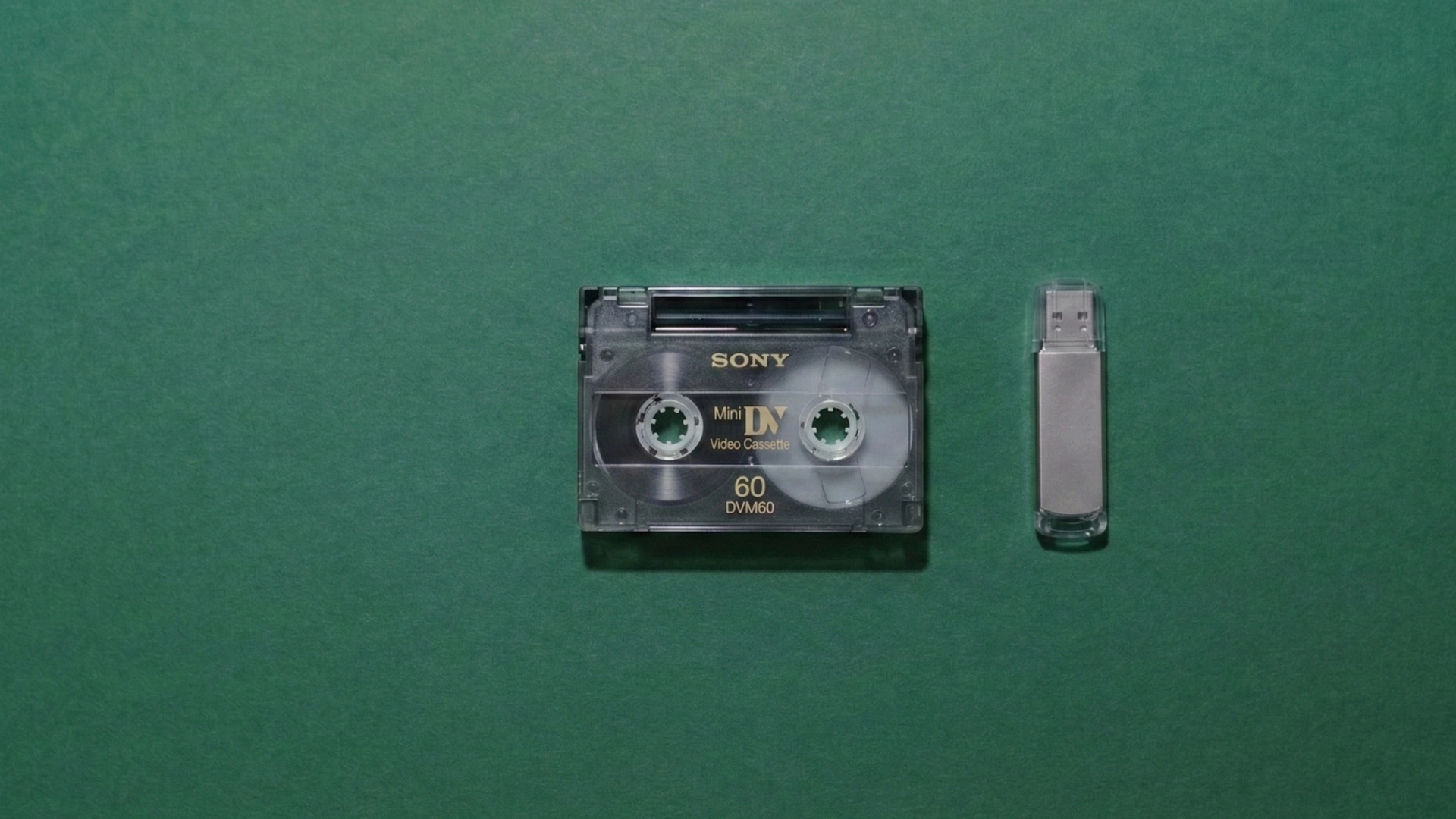 Mini-DV cassette with USB drive showing digital transfer